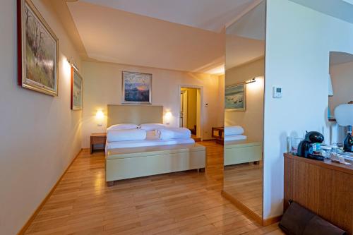 a hotel room with a bed and a mirror at Hotel Baia D'Oro - Adults Only in Gargnano