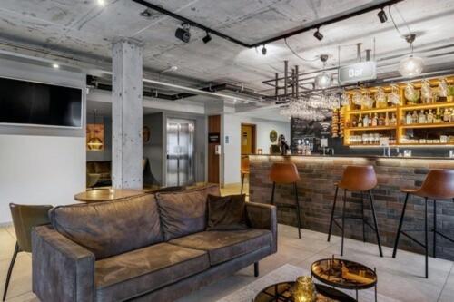 ein Wohnzimmer mit einem Sofa und einer Bar in der Unterkunft Konvin Hotel by Reykjavik Keflavik Airport in Keflavík