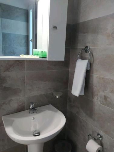 a bathroom with a white sink and a mirror at Πλατανακι 1 Family Friendly in Andros