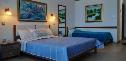 a bedroom with a blue bed and a mirror at villa vagelis in Mourteri
