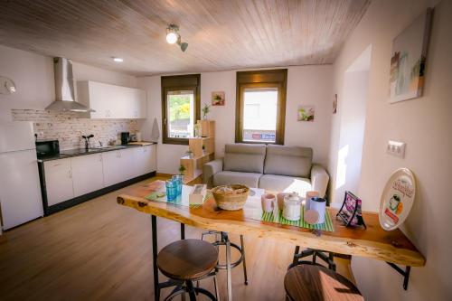 eine Küche und ein Wohnzimmer mit einem Tisch und einem Sofa in der Unterkunft O Lar do Camiñante in Palas de Rei