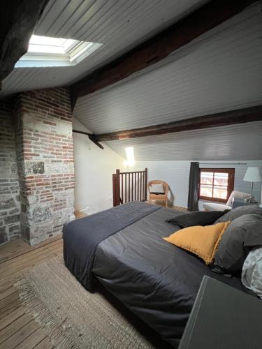 una camera da letto con un grande letto e un muro di mattoni di La marinière a Honfleur