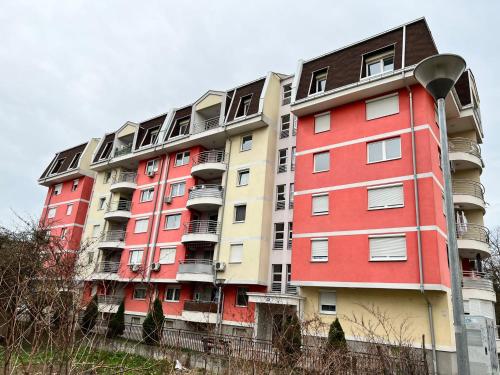 un grand immeuble d'appartements avec rouge et jaune dans l'établissement Apartman Lana, à Doboj