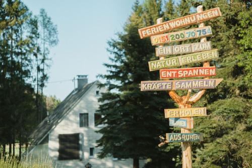 a street sign with many signs in front of a house at Ferienhaus Untere Zeitelwaidt in Bad Steben