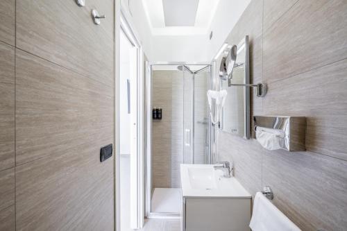 W łazience znajduje się umywalka i lustro. w obiekcie Resp Suites Novara w mieście Novara