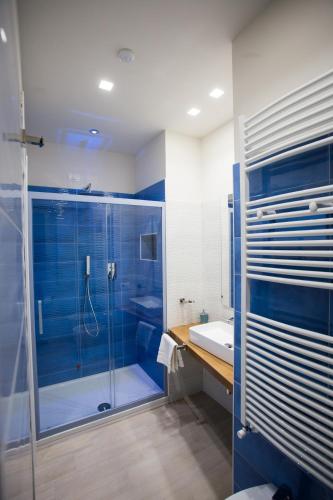 a blue bathroom with a shower and a sink at B&B DELICIUS in Scalea