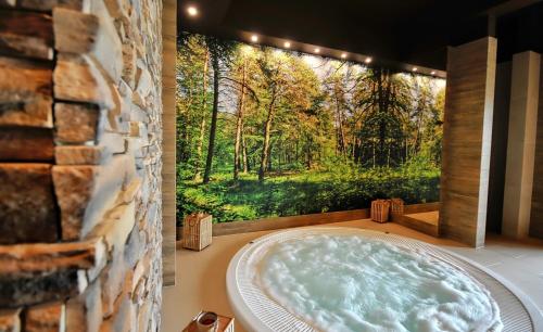 une baignoire jacuzzi avec vue sur la forêt dans l'établissement Amberia, à Grzybowo