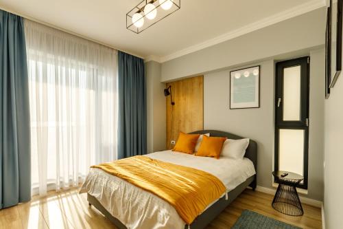 ein Schlafzimmer mit einem Bett mit orangefarbenen Kissen in der Unterkunft Lucky 13 in Mamaia