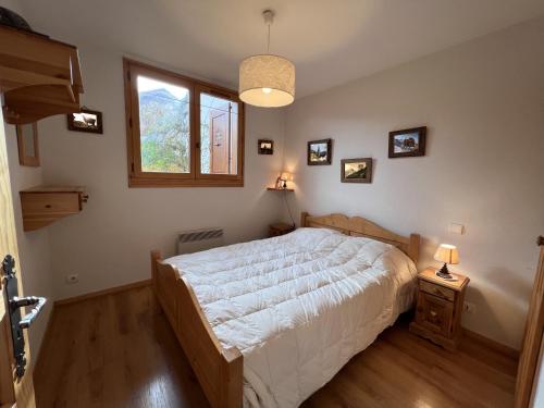 une chambre avec un grand lit et une fenêtre dans l'établissement Tendieu Soleil B - Appartement dans chalet, vue montagnes, à La Clusaz