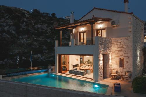 a villa with a swimming pool in front of a house at Villa Almy in Plaka