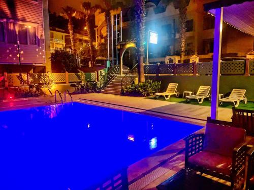 a swimming pool at night with a chair next to a building at Latino Hotel in Kemer