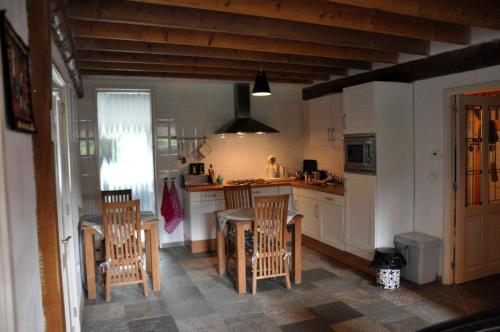 a kitchen with a table and chairs and a counter at B&B Kelpiebrink in Baarle-Nassau