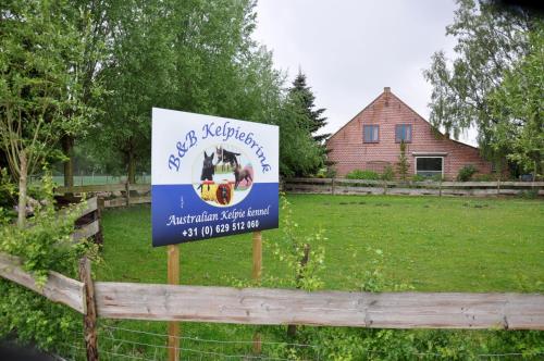 a sign on a fence in a yard at B&B Kelpiebrink in Baarle-Nassau