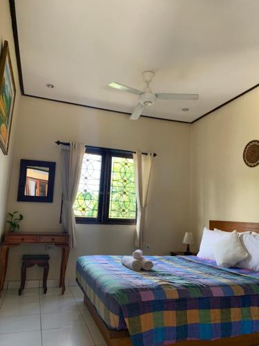 Un dormitorio con una cama con un osito de peluche. en Rama Homestay en Ubud
