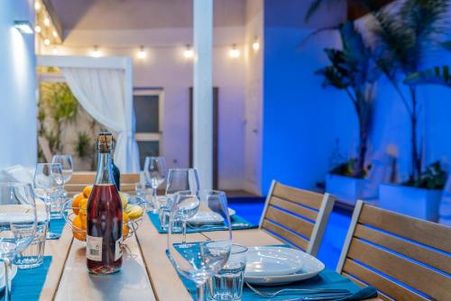 a table with a bottle of wine and glasses on it at VLVilla - Villa de lujo en Valencia con piscina privada y sala de cine in Burjasot