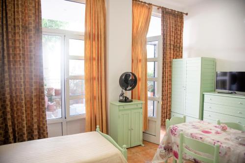 a bedroom with a table and a dresser and a window at STAVROS Studio Apartment in kos town in Kos Town