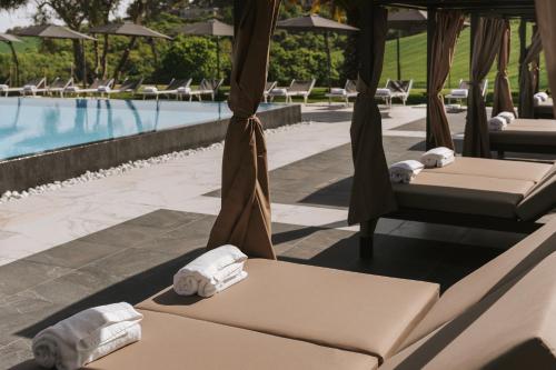 a row of beds next to a swimming pool at Pietra Bianca Hotel in Numana