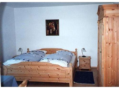 1 dormitorio con cama de madera y una foto en la pared en Appartement Haus Anja, en Bad Füssing