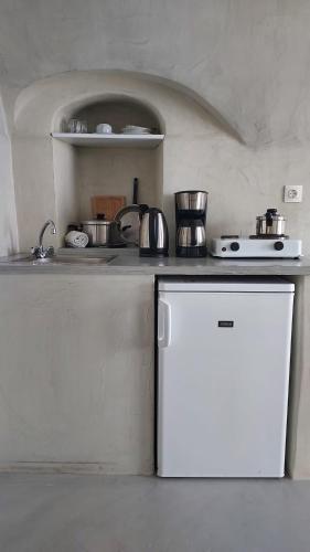 a kitchen with a white refrigerator and a stove at Olympic Villas in Oia