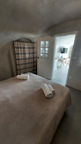 a bedroom with a large bed with two towels on it at Olympic Villas in Oia