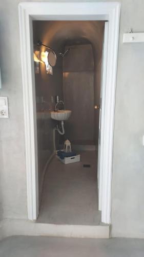 a hallway leading to a bathroom with a sink at Olympic Villas in Oia