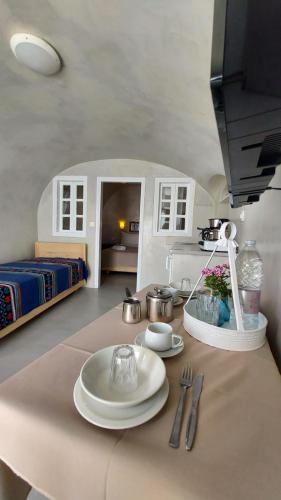 a table with plates and utensils on top of it at Olympic Villas in Oia