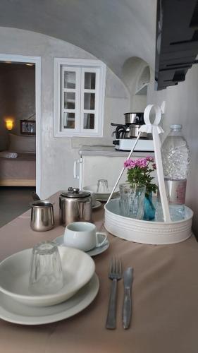 a kitchen counter with plates and utensils on a table at Olympic Villas in Oia