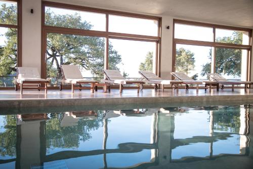 a pool with chaise lounge chairs next to the water at Sasseta Alta in Scansano