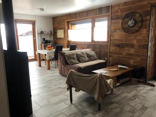 un salon avec un canapé et une table dans l'établissement maison de village au pied des 3 Vallées, à Villarlurin