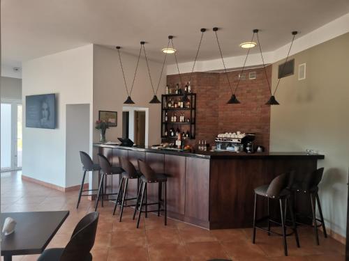 a bar with black stools in a room at Golf Hotel Lisia Polana in Pomocnia