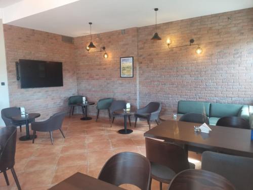 un restaurante con mesas y sillas y TV en una pared de ladrillo en Golf Hotel Lisia Polana en Pomocnia