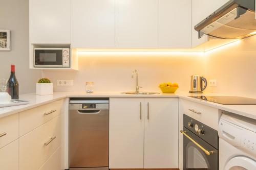 a white kitchen with a sink and a dishwasher at Ses Fonts C25 in Son Parc