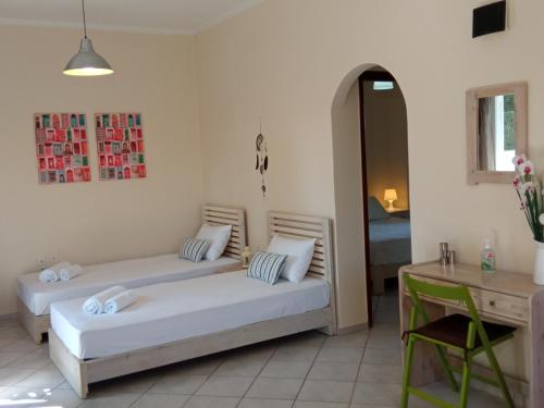 two beds in a room with a table and a desk at Sea Side House Kourouta in Kourouta