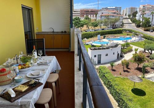 a table on a balcony with a view of a pool at Muralha Residence in Lagos