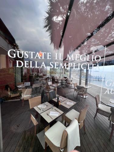 a restaurant with tables and chairs on a deck at Brissago Lake Apartment in Brissago