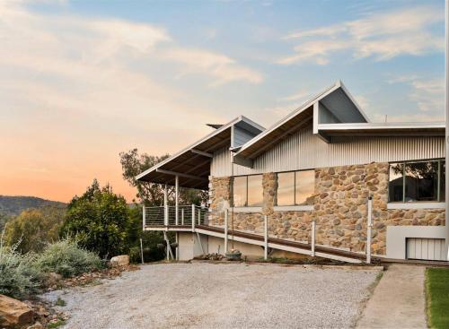 a stone house with a large driveway at The Riverstone Luxury Eco Home in the Hills in Mudgee