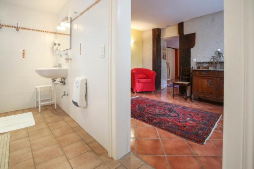 a bathroom with a sink and a red chair at Domaine Les Bachats in Rhodes