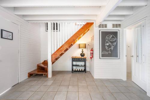a staircase in a house with a white wall at The Riverstone Luxury Eco Home in the Hills in Mudgee