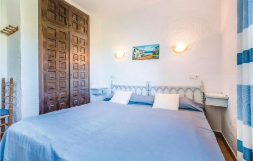 a bedroom with a blue bed and a wooden door at Costa Nova in Jávea