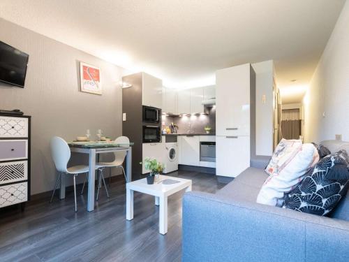 un salon avec un canapé bleu et une table dans l'établissement Appartement rénové 4 personnes calme proche centre Saint-Lary - FR-1-296-241, à Saint-Lary-Soulan