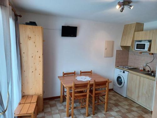 une cuisine avec une table et des chaises et un micro-ondes dans l'établissement 2 pièces + cabine avec balcon et kitchenette équipée - FR-1-573-56, à Le Biot