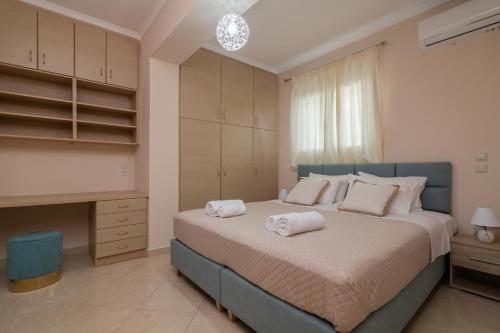 a bedroom with a large bed with towels on it at Taso's Modern House! in Zakynthos