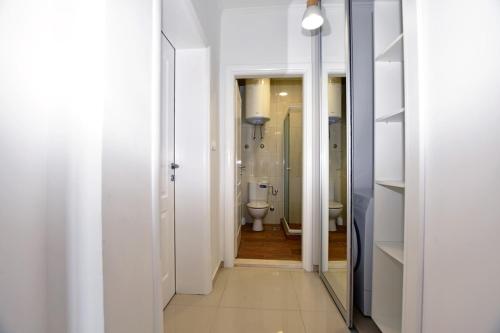 a white bathroom with a toilet and a mirror at Jednosoban stan Milinic in Herceg-Novi