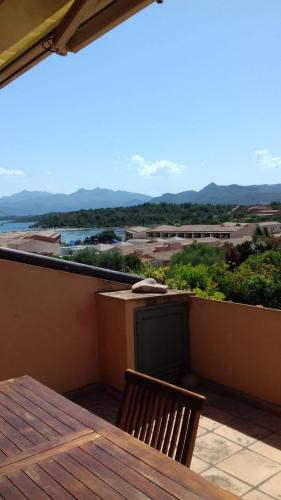 a table and chair on a balcony with a view at Residenze Coda Cavallo in San Teodoro