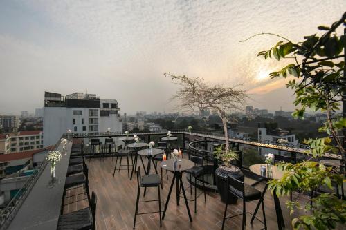a balcony with tables and chairs on a building at La Nueva Boutique Hotel Hanoi & Spa in Hanoi