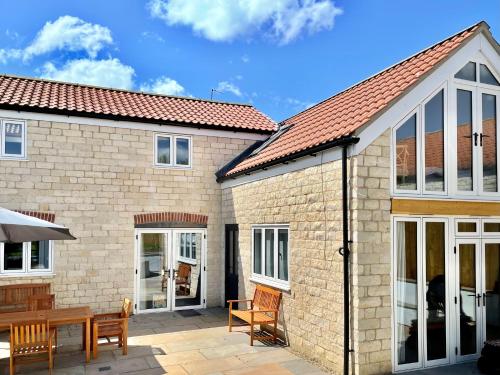 a house with sliding glass doors and a patio at Rye Court Cottage - Stunning cottage in central Helmsley with parking in Helmsley