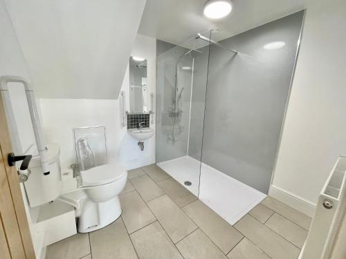 a white bathroom with a shower and a toilet at Rye Court Cottage - Stunning cottage in central Helmsley with parking in Helmsley