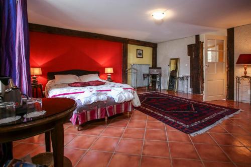 a bedroom with a bed with a red wall at Domaine Les Bachats in Rhodes