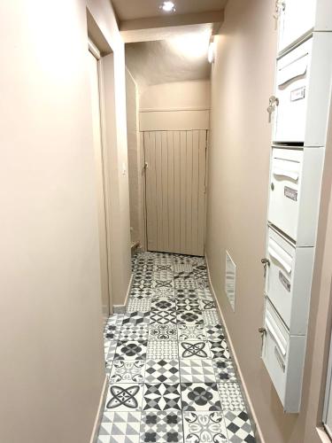 um corredor com piso em azulejo preto e branco em Studio République #3 em Perpignan
