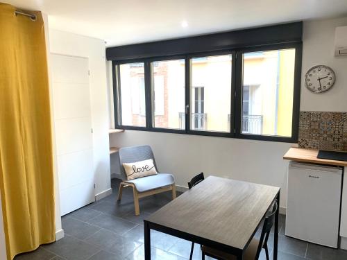 uma cozinha com uma mesa, uma cadeira e uma janela em Studio République #3 em Perpignan